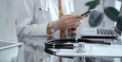Close-up of doctor's desk with stethoscope and digital tablet in flair medical office. Medicine and health care