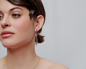 Elegant woman in bright dress shows off her beautiful gold jewelry
