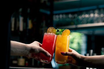 Close up of two people cheering cocktails in bar or disco club drinks and cocktails concept