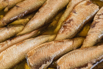 Smoked sprats without heads in cooking oil, close-up