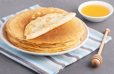 Stack of traditional russian pancakes blini on gray background with copy space. Homemade russian...