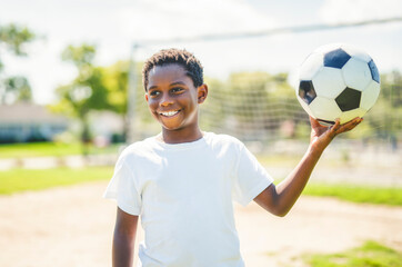 Naklejka premium Young kid playing soccer on a playfield