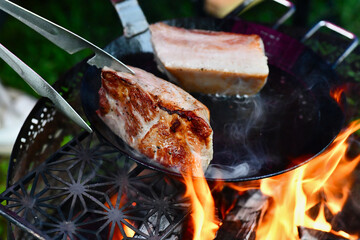 焚き火で肉の塊を焼く