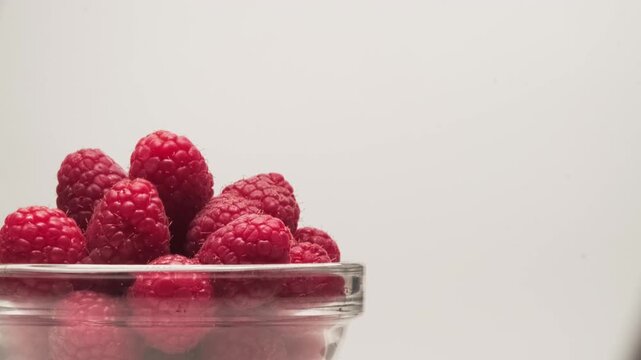 Close-up of a bowl of ripe scarlet raspberries on a