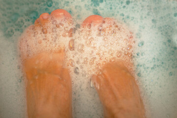 Legs covered with foam in blue water. Blue water with foam bubbles