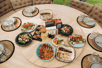 A festive and beautifully decorated wedding table. Decorated with flowers.various bottles of drinks, beautiful dishes, salads and sliced meat rolls.vegetable slicing.