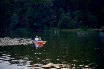 the couple in love kayaking on the river at sunset