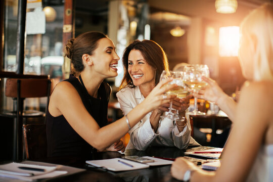 Businesswomen toasting with wine glasses in a restaurant