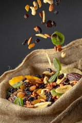 Dried tropical fruits and nuts in burlap bag.