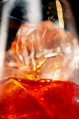 macro frame of a wine glass on a black background with coarsely crushed ice in a glass orange...