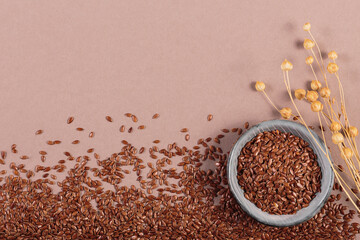 Brown linen seeds on beige background. Flaxseed background. Healthy super food top view, flat lay...