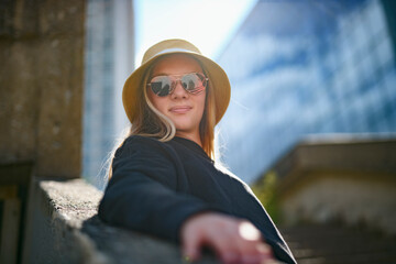 young girl standing at city street. Outside portrait of joyful beautiful teen over urban background.