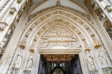 Obraz premium ROUEN, NORMANDY, FRANCE - 2024: Church of Saint Maclou, west portal with richly decorated tympanum, displays a Christ statue standing with his hands held out