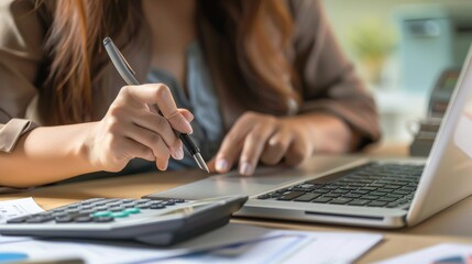 Woman accountant use calculator and computer with holding pen on