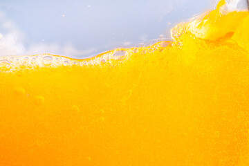 Close up bright orange juice splash texture for health and nature waves, Beautiful waves curve and little bubbles smooth for garphic design and background