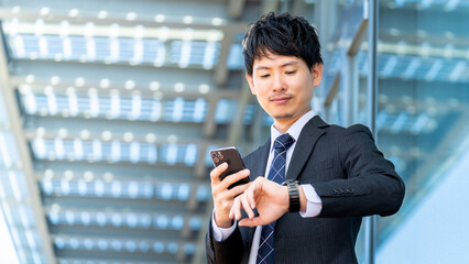 腕時計を見る日本人男性ビジネスマン