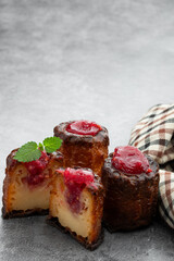 Canelé with raspberry jam on gray background