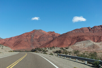 Ruta al lado de montañas rojizas.