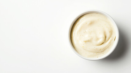 Caesar dressing in a small dish, isolated on a white background. The focus is on the sauce’s creamy consistency and flecks of cheese