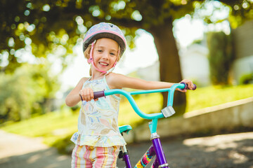 kid girl of 4 years having fun when cycling on the bicycle