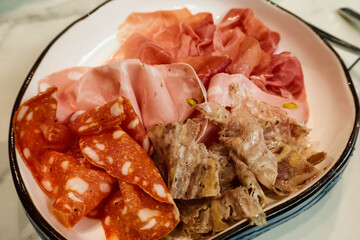 close up of assorted mixed parma,  serrano ham cold cut platter on a plate