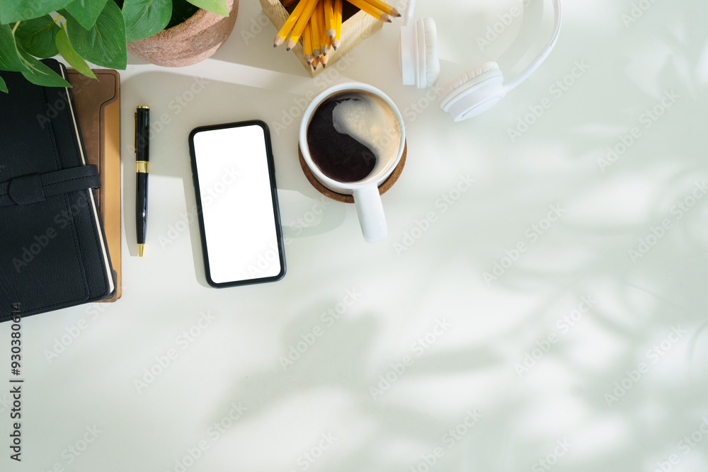 Poster top view smart phone with empty screen, notebook and coffee cup on office desk. copy space for your 