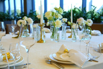 Table setting in a restaurant. Empty glasses set in restaurant. Table setting with glasses, cutlery and plates. Restaurant interior.