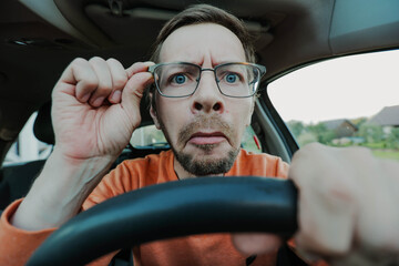 Young man have problems with driving due poor eyesight, hand holding eyeglasses