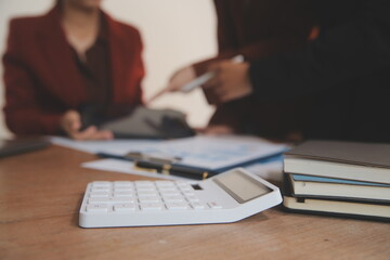 Fototapeta premium Group of confident business people point to graphs and charts to analyze market data, balance sheet, account, net profit to plan new sales strategies to increase production capacity.