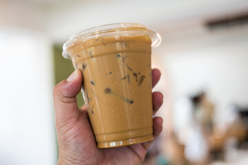 Iced coffee espresso in a plastic glass, summer drink concept