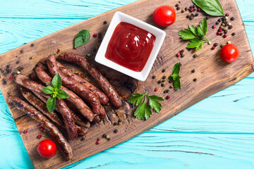 Grilled sausages with tomatoes , pepper and rosemary`. BBQ food background