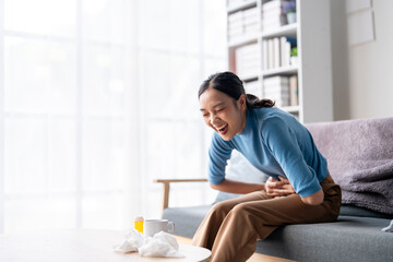 A woman is laughing while sitting on a couch