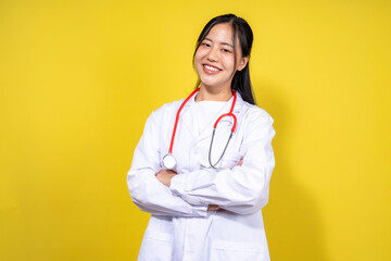A woman in a white lab coat is smiling and holding her arms crossed