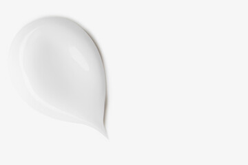 A smear of white cosmetic cream on a light background.