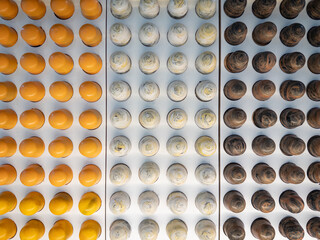 Top View of Chocolate  bon bons in yellow, white and brown arranged in a grid