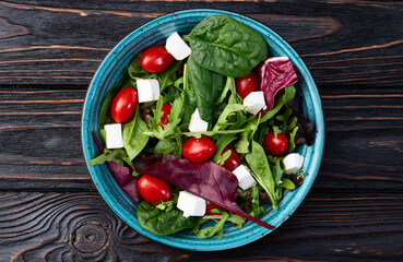 Summer salad with arugula, spinach, cherry tomatoes and cheese feta