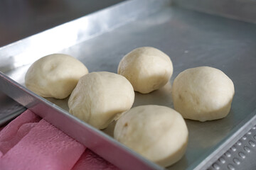 Rounded dough in a baking tray