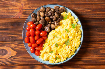 Homemade scrambled eggs with mushrooms and cherry tomatoes