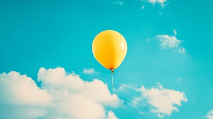 Yellow balloon floating in blue sky with