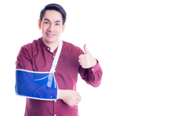 Cheerful asian man with his arm in a blue sling, giving a thumbs up while wearing a red shirt. The image portrays positivity and resilience despite injury, set against a white background.