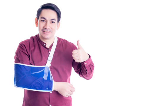 Cheerful asian man with his arm in a blue sling, giving a thumbs up while wearing a red shirt. The image portrays positivity and resilience despite injury, set against a white background.