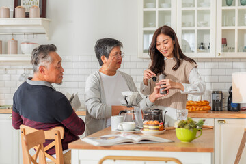 happiness asian family bonding family reunion fresh coffee bean drip process together in kitchen Drip coffee Mature woman pouring coffee cup for senior woman sitting at dining table lifestyle family