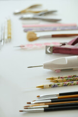 Various artistic tools, such as paintbrushes and decorative pens, displayed neatly on white background These tools may be used for painting, drawing, and other creative activities