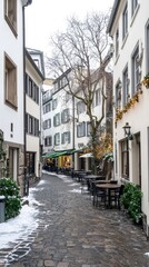 Snow blankets the ground as warm lights illuminate the festive street, lined with decorated trees and cozy cafe tables inviting visitors to enjoy the holiday charm