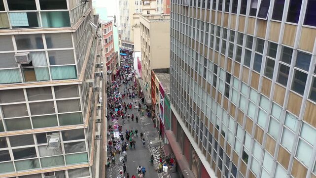 Aerial view of Ladeira Porto Geral in S&atilde;o Paulo, Brazil, showing a crowded street market between tall buildings.