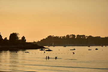 Evening Fun: Silhouettes of Youth Playing in the Sea at Ladeira Beach