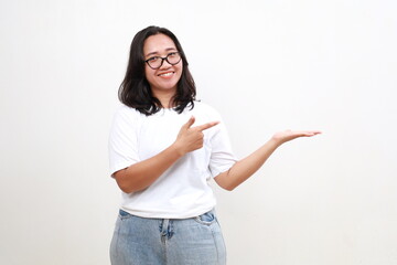 Smiling cheerful cute asian woman making announcement, demonstrate new product on hand, pointing finger at blank space for your advertisement, standing over white background