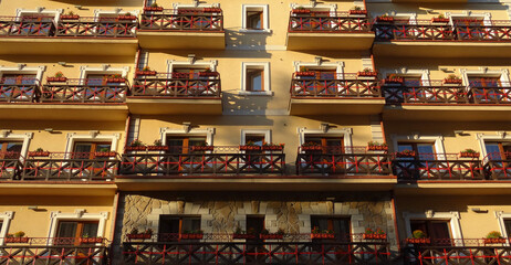 Facade Of Traditional Architecture Style House With Wooden Timber Framing Balconies Decorated With Street Flowers
