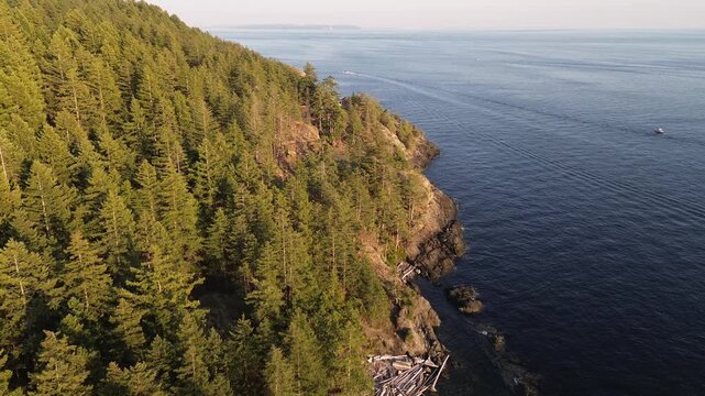 Drone showing mountain covered by green treesat Bowen Island in British Columbia during sunset time