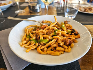 Strozzapreti alla marinara freshly prepared pasta with seafood served at a cozy restaurant during lunchtime in  San Marino